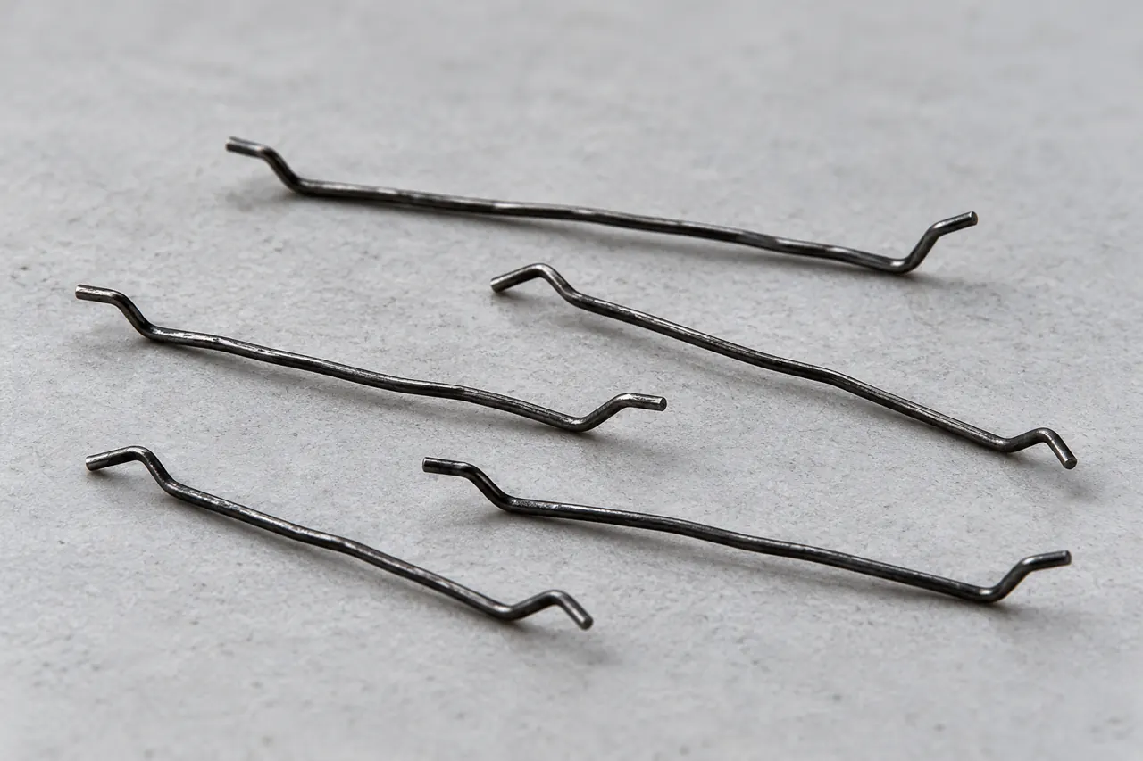 Individual slender steel fibres showing short hooked bends at both ends