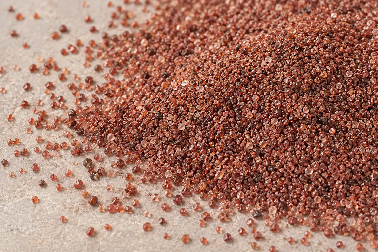 Close view of angular red-brown garnet grains on a neutral surface